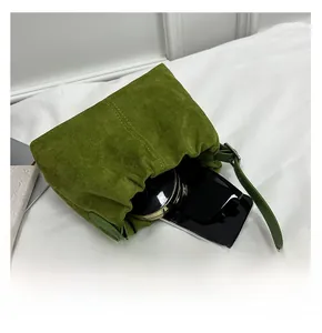 Interior view of the green suede bucket bag showing storage capacity for phone and makeup