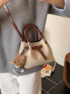 Sac seau en daim beige cassé avec poignées marron et pendentif ours en peluche