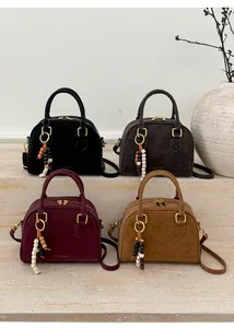 Detailed view of four colorful lychee faux leather Boston bags with wooden bead charms
