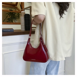 Close-up of red crescent moon shoulder bag with silver buckle and fashion branding
