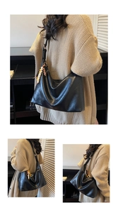 Close-up of black leather hobo bag with colorful bead charm on soft knit sweater