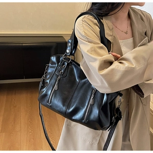 Detailed view of black retro tote bag with silver zippers, metal rivets and ring buckles
