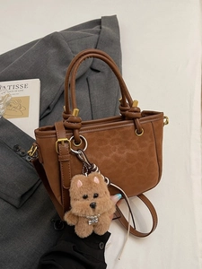 Borsa tote opaca leopardata marrone con manico a nodo e ciondolo a cane in scena lifestyle