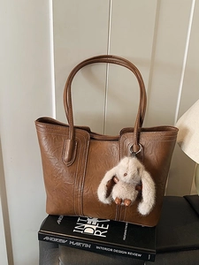 Braune Shopper-Tasche aus Leder mit weißen Nähten und Kaninchen-Anhänger im Vintage-Stil