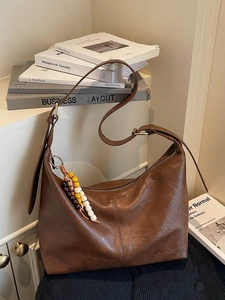 Vintage brown hobo shoulder bag with bohemian beaded tassel and natural leather texture