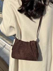Dark brown pleated suede bucket bag with stylish shoulder strap for autumn fashion