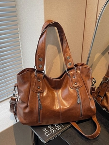 Caramel brown vintage tote bag with metal studs and zippers for daily commuting style