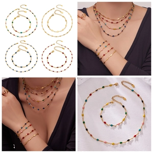 Detail view of colorful enamel beads and golden chain on necklaces and bracelets