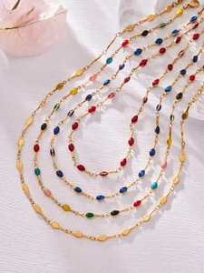Detailed close-up of bohemian gold link necklaces with multi-color enamel inlay charms
