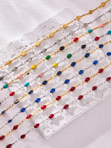 Close-up of colorful enamel teardrop charms on gold and silver stainless steel chains