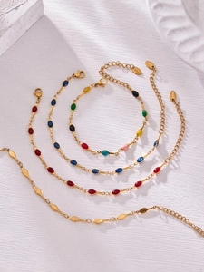 Detail of gold stainless steel bracelet set with colorful enamel oval charms and lobster clasp