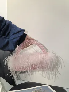 Close-up of pink beaded handbag with fluffy ostrich feathers for evening parties