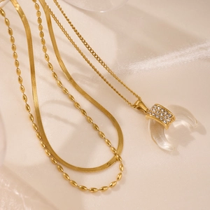 Three-layer 18k gold plated moon pendant necklace with resin zircon on silk background