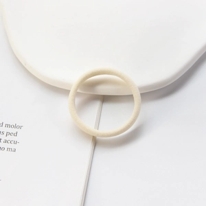 Close-up of high-elasticity seamless cream hair tie on decorative minimalist tray