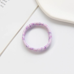 Close-up of pink and purple marble pattern elastic hair tie on a white surface