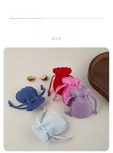 Flat lay of velvet drawstring jewelry pouches in five colors with ribbon bow details