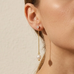 S925 sterling silver drop earrings with freshwater pearls and long gold tassels on a model