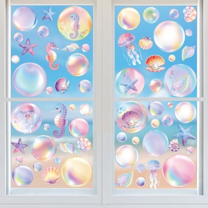 Macro detail of iridescent ocean creature window stickers on glass with beach background