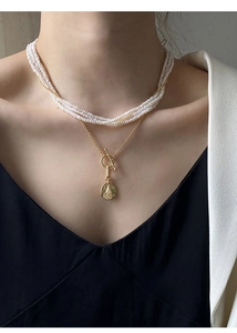 Detail of layered S925 silver pearl necklace with gold coin pendant and OT toggle clasp