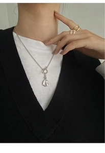 Detail of silver S925 hammered round pendant necklace with OT buckle on model