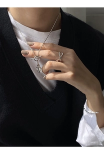 Detailed view of silver OT toggle necklace with hammered pendant and beaded chain design