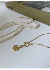 Detail of S925 silver golden OT clasp necklace with vintage round medal pendant