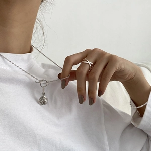 Detail of silver S925 necklace with OT clasp and irregular textured coin pendant set