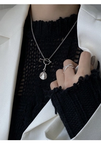 Macro detail of S925 silver toggle clasp necklace with wrinkled metal disc pendant