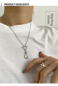 Detailed view of S925 sterling silver OT buckle necklace and ring on a white T-shirt
