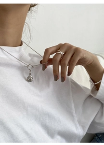 Detail of S925 silver OT buckle necklace with coin pendant and crisscross ring on model