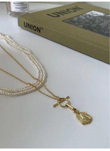 Detail of S925 silver pearl necklace with hammered gold pendant and OT toggle clasp