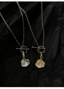 Detailed close-up of textured gold and silver irregular pendants with OT buckle closure