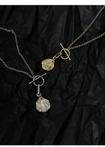 Detailed macro view of S925 silver OT buckle necklaces with irregular hammered pendants