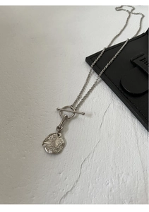 Close-up of S925 sterling silver hammered coin pendant with toggle clasp detail