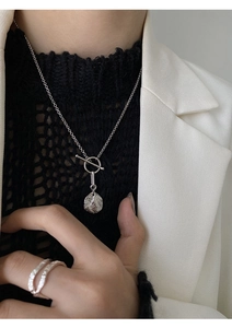 Detail of S925 silver OT buckle necklace with textured pendant on a model