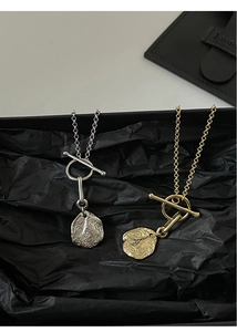 Detail of gold and silver irregular hammered pendants with chic OT toggle clasp
