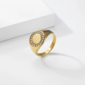 Detailed view of a gold-plated signet ring with a circle of pavé set white crystals