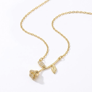 Elegante collana con ciondolo a rosa dorata e zirconi scintillanti su sfondo bianco