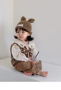 Detailed knit of a brown baby beanie with rabbit ears and premium textured fabric