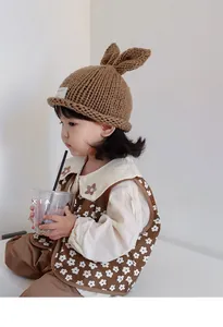 Close-up of brown knit baby hat with 3D bunny ears and soft handmade texture
