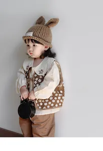 Detailed view of handmade knitted bunny ear hat with vintage floral vest and shirt set