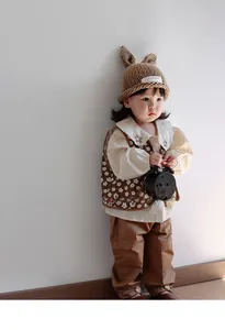Detail of baby girl knitted bunny ear hat and vintage floral embroidery outfit set
