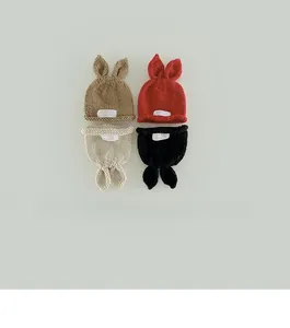Detail of hand-knitted baby beanies with cute rabbit ears in four stylish colors