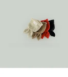 Detail of hand-knitted baby beanies with cute rabbit ears in four neutral colors