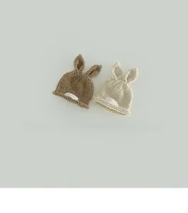 Detail of handmade knit baby hats with rabbit ears in brown and beige colors