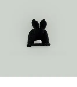 Detailed knit of black baby hat featuring cute 3D ears and a white woven label