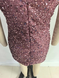Detail of pink sequin dress showing fabric texture and fine stitching on the back