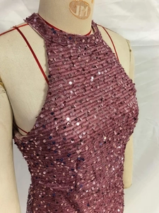Detail view of pink sequin fabric and halter neck design on a luxury evening dress