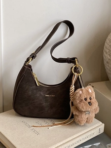 Minimalist dark brown crescent hobo bag with gold zipper and plush dog keychain