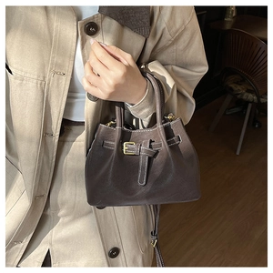 Sac seau en cuir marron texturé avec surpiqûres blanches et boucles dorées au café